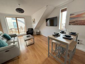 una sala de estar con una mesa y un sofá en Millgrove House Apartments, en Eastbourne