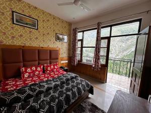 - une chambre avec un lit et une grande fenêtre dans l'établissement Mountain Trail, à Dharamshala