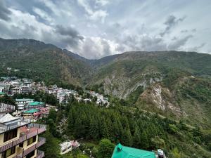 - une vue sur une ville avec des montagnes en arrière-plan dans l'établissement Mountain Trail, à Dharamshala
