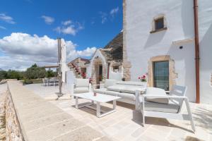 a patio with white furniture and a white building at Trulli Tower in Putignano