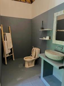 La salle de bains est pourvue de toilettes et d'un lavabo. dans l'établissement Green Coco House, à Amed