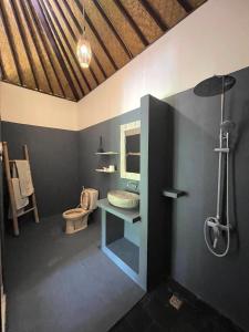 La salle de bains est pourvue d'un lavabo et de toilettes. dans l'établissement Green Coco House, à Amed
