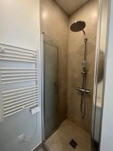 La salle de bains est pourvue d'une douche avec une porte en verre. dans l'établissement Appartement cosy à 1 min de Paris, à Charenton-le-Pont