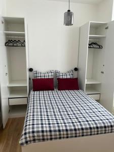 - une chambre avec un lit doté d'oreillers rouges et d'étagères dans l'établissement Appartement cosy à 1 min de Paris, à Charenton-le-Pont