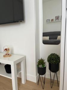 une chambre avec une table blanche et deux plantes en pot dans l'établissement Appartement cosy à 1 min de Paris, à Charenton-le-Pont
