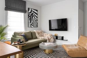 Lion Apartments - SCALA City Center Premium Apartments with parking E في غدانسك: غرفة معيشة مع أريكة وطاولة