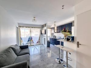 a living room with a couch and a kitchen at Juan-Les-Pins 150m des plages 6 couchages Parking in Juan-les-Pins