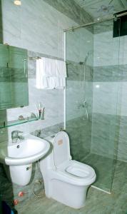 e bagno con servizi igienici, lavandino e doccia. di Mi Linh Hotel a Nha Trang