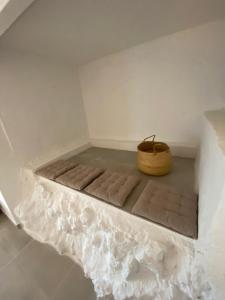 Cama en habitación con cesta en el suelo en Pandi's Place, en Sant Pere de Ribes