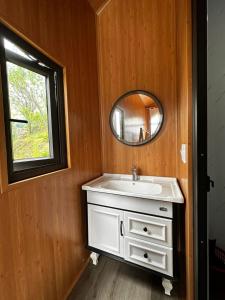 ein Badezimmer mit einem weißen Waschbecken und einem Spiegel in der Unterkunft Sapa Wind’s House in Lào Cai