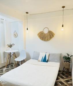 Un dormitorio con una cama blanca y una mesa. en StayNest Matabungkay - Private Vacation House, en Lian