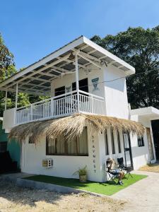 a white house with a porch and a balcony at StayNest Matabungkay - Private Vacation House in Lian