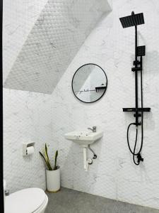 Un baño blanco con lavabo y espejo. en StayNest Matabungkay - Private Vacation House, en Lian