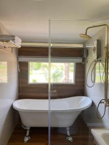 eine Badewanne im Bad mit Fenster in der Unterkunft Nex Station Kanchanaburi in Kanchanaburi