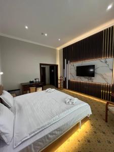 1 dormitorio con 1 cama grande y TV de pantalla plana en Mixt Royal Palace en Samarcanda