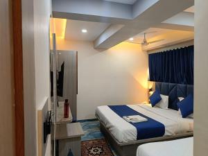 Habitación de hotel con cama con sábanas azules en hotel shivkunj, en Ahmedabad