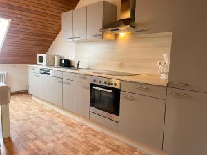 eine Küche mit Küchengeräten aus Edelstahl und Holzwänden in der Unterkunft Haus Duhner Strandblick FeWo 7 in Cuxhaven