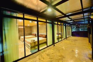 a large room with a bed and some windows at Phuniphat Pool Villa in Nong Prue