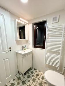 ein Bad mit einem Waschbecken, einem WC und einem Fenster in der Unterkunft House Of Harry - horská chata in Liberec
