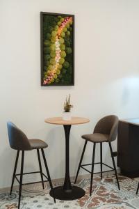 una mesa con dos sillas y una foto de una vid de uva en Lifestyle and Suites en Civitavecchia