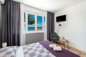 sypialnia z łóżkiem, oknem i krzesłem w obiekcie Apartmani Stanka w Podstranie
