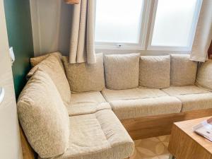 - un canapé dans le salon doté d'une fenêtre dans l'établissement Mobile-home MAZET 93 à Vias, à Vias