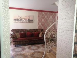 a living room with a red couch and a staircase at Liepu Residence in Olayne