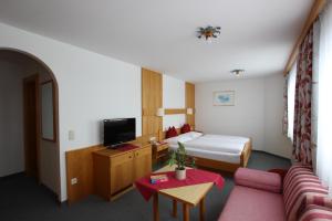 pokój hotelowy z łóżkiem i kanapą w obiekcie Hotel Garni Bel-Ami w mieście Galtür