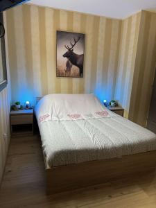 a bedroom with a bed and a picture of a deer at Gîte du Bambi in Gerbamont 