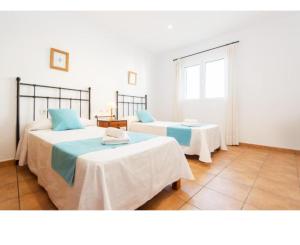 a bedroom with two beds and a window at Casa Maria in Fornells
