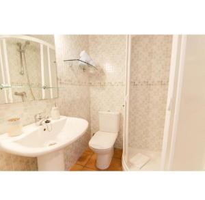 a bathroom with a toilet and a sink and a shower at Casa Maria in Fornells +6 photos