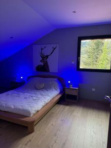 a bedroom with a bed with a deer painting on the wall at Gîte du Bambi in Gerbamont 