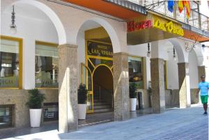 un hombre caminando por una calle frente a una tienda en Hotel Las Vegas, en Benidorm