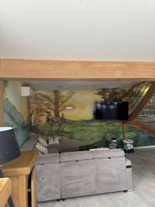 a living room with a wall with a mural at Gîte du Bambi in Gerbamont 