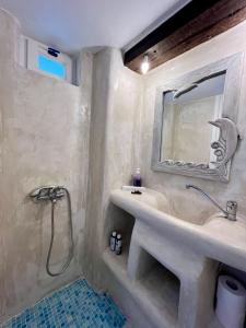 W łazience znajduje się umywalka i lustro. w obiekcie Lorentzo Rooms w mieście Kionia