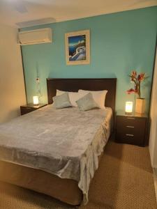 a bedroom with a large bed with two night stands at Your Coral Coast Resort Inn in Palm Cove