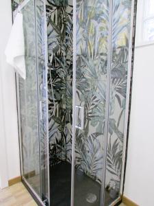 une douche dans une pièce avec un mur de plantes dans l'établissement Casa Ribes Rooms, l'angolo tranquillo alle porte della città, à Olbia