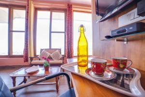 eine Küche mit einer Flasche auf einer Theke mit zwei Tassen in der Unterkunft The Onyx Abode in Dharamsala