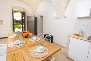 uma cozinha e sala de jantar com uma mesa de madeira em Villa Angelita by Villa Plus em Ceglie Messapica