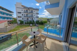 a balcony with a table and chairs and a view of a building at Hotel Esmerald Ksamil in Ksamil