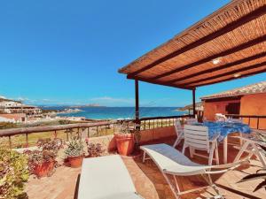 un patio con mesa, sillas y el océano en Beach Home Baja Sardinia, en Baja Sardinia