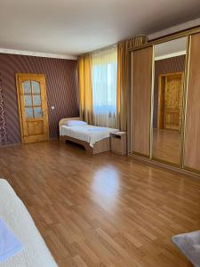 a large room with two beds and a mirror at Mini-Hotel "Nord" in Chynadiyovo