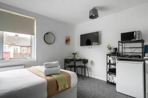 Schlafzimmer mit einem Bett, einem Tisch und einem Fenster in der Unterkunft Livestay Affordable En-Suite Studio Rooms in London, N14 in East Barnet