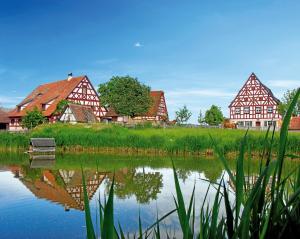 een bankje voor een meer met huizen bij das windsHEIM Appartements by Vital Hotel in Bad Windsheim