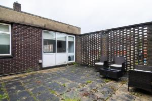 een patio met 2 stoelen en een gebouw bij Livestay Affordable En-Suite Studio Rooms in London, N14 in East Barnet