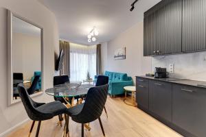 eine Küche und ein Wohnzimmer mit einem Tisch und Stühlen in der Unterkunft Downtown Apartments Riverside Nadmotławie Estate - Gym & Sauna in Danzig