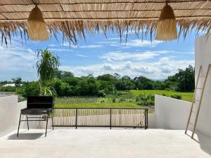 a patio with a chair and a view of a field at Tujuan Jogja Villas With Private Pool in Jetis