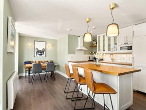 uma cozinha e sala de jantar com mesa e cadeiras em The Executive at Clifden Boutique Apartments em Clifden