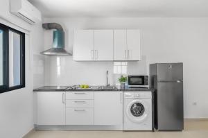 a kitchen with a refrigerator and a washing machine at Cozy Paradise Apartment in Soo