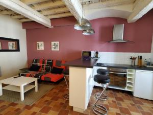 een keuken en een woonkamer met een rode muur bij REPUBLIQUE CENTRE Nouvelle Gestion et Ménage 2024 in Carcassonne